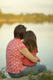 Girl with mother near river